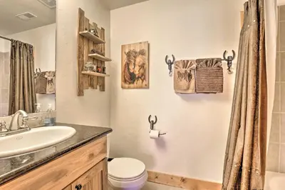 a bathroom with a sink and a toilet and a mirror at Deck, Bar and Mtn Views Grand Granby Retreat! in Granby