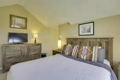 a bedroom with a bed and a flat screen tv at Walk to Ski Lifts Mtn-View Granby Retreat! in Granby
