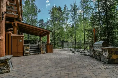 an outdoor patio with a grill and a building at Jackpine Lodge 2 Bedroom Condo in Keystone