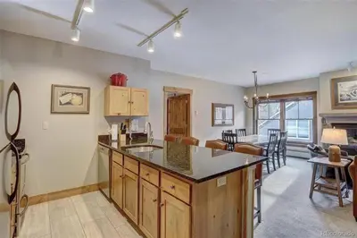 a kitchen with a counter top and a living room at Jackpine Lodge 2 Bedroom Condo in Keystone
