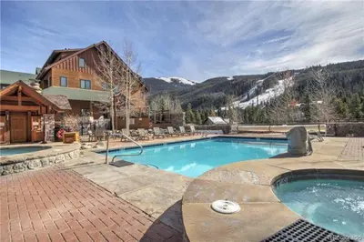 a large swimming pool in front of a house at Jackpine Lodge 2 Bedroom Condo in Keystone