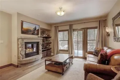 a living room with a couch and a fireplace at 2 Bedroom Blackbear Lodge Condo In River Run Village in Keystone
