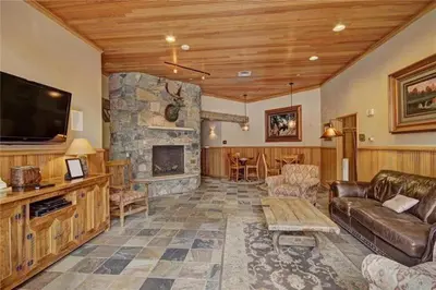 a living room with a couch and a stone fireplace at 2 Bedroom Blackbear Lodge Condo In River Run Village in Keystone