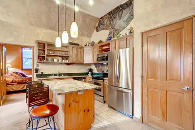 a kitchen with a refrigerator and a table and chairs at Black Bear Lodge 3 Bedroom Condo In River Run Village in Keystone