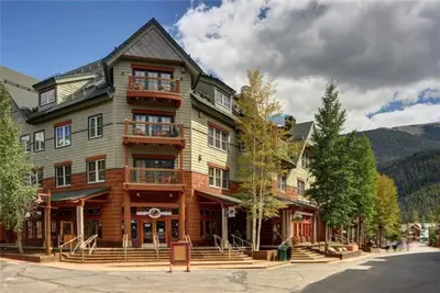 a large wooden building with a balcony on a street at Black Bear Lodge 3 Bedroom Condo In River Run Village in Keystone