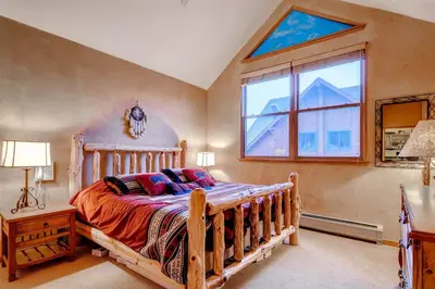 a bedroom with a wooden bed and a window at Black Bear Lodge 3 Bedroom Condo In River Run Village in Keystone
