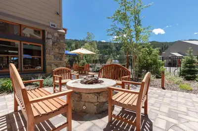 a patio with three chairs and a table with a cat sleeping on it at Black Bear Lodge 3 Bedroom Condo In River Run Village in Keystone