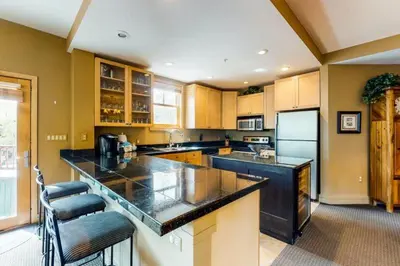a large kitchen with black counter tops and a refrigerator at 8166 Silver Mill in Keystone
