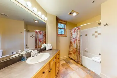 a bathroom with a sink and a mirror and a tub at 8166 Silver Mill in Keystone