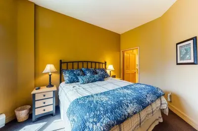 a bedroom with a bed and a yellow wall at 8166 Silver Mill in Keystone