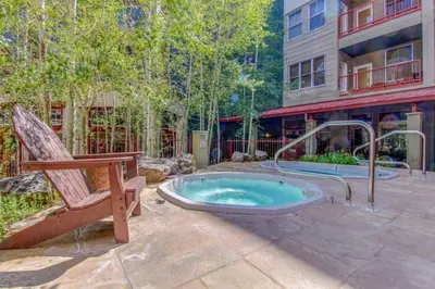 a hot tub in a patio with a bench and a chair at 8166 Silver Mill in Keystone