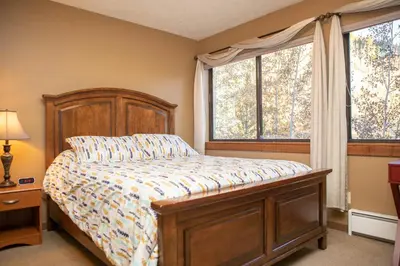a bedroom with a bed and two windows at 1221 Keystone Gulch condo in Keystone