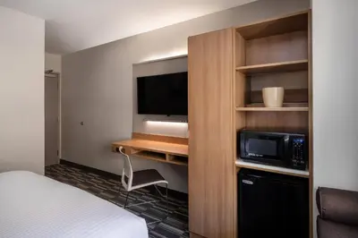 a hotel room with a bed and a microwave and a tv at Microtel Inn & Suites by Wyndham Georgetown Lake in Georgetown