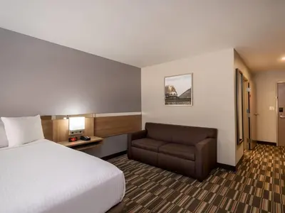 a hotel room with a bed and a chair at Microtel Inn & Suites by Wyndham Georgetown Lake in Georgetown