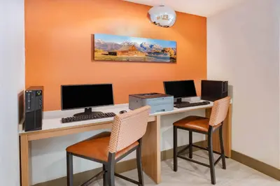 a computer desk with two monitors and two chairs at Microtel Inn & Suites by Wyndham Georgetown Lake in Georgetown