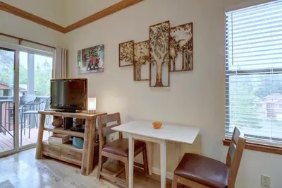 a living room with a table and a tv at 201C Mountain Side 1BR 1BA condo in Frisco