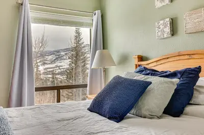 a bedroom with a bed and a window with a view at Ski, Shred and Tube Mtn-View Condo in Silverthrone! in Silverthorne