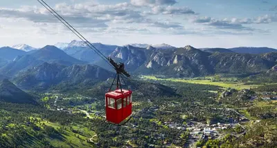 a red cable car flying in the mountains at Beautiful Views! Jacuzzi, Indoor/ Outdoor Fireplace, Steps to Lake Estes in Estes Park