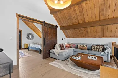 a living room with a couch and a table at Beautiful Views! Jacuzzi, Indoor/ Outdoor Fireplace, Steps to Lake Estes in Estes Park