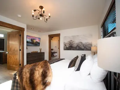 a cat sitting on a bed in a bedroom at Beautiful Views! Jacuzzi, Indoor/ Outdoor Fireplace, Steps to Lake Estes in Estes Park