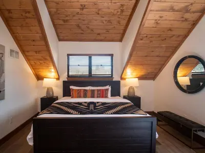 a bedroom with a large bed with a wooden ceiling at Relax in Luxury - Jacuzzi, Indoor/Outdoor Fireplace in Estes Park