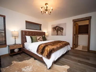 a bedroom with a bed with a faux fur blanket at Relax in Luxury - Jacuzzi, Indoor/Outdoor Fireplace in Estes Park