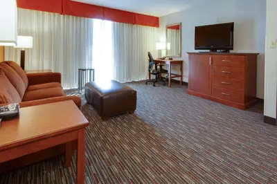a hotel room with a couch and a flat screen tv at Drury Inn & Suites Denver Tech Center in Centennial