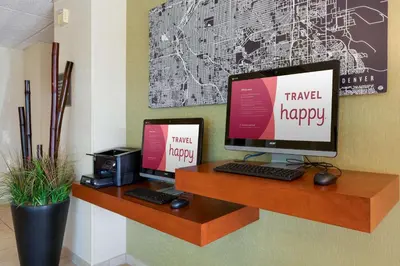 a desk with two computer monitors and a printer at Drury Inn & Suites Denver Tech Center in Centennial