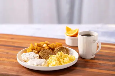 a plate of breakfast food and a cup of coffee at Drury Inn & Suites Denver Tech Center in Centennial