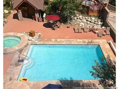 a swimming pool in a yard with a patio and a house at 8176 Silver Mill condo in Keystone