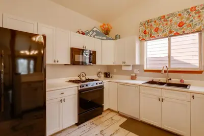 a kitchen with white cabinets and a black stove top oven at 8 Mi to Copper Mtn Dtwn Frisco Retreat with Deck! in Frisco