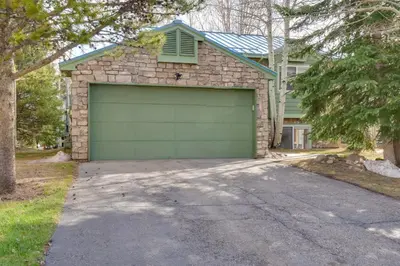 a garage with a green garage door in front of a house at 8 Mi to Copper Mtn Dtwn Frisco Retreat with Deck! in Frisco