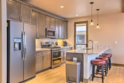 a kitchen with stainless steel appliances and wooden cabinets at Relax Fireside Silverthorne Home 11 Mi to Skiing! in Silverthorne