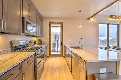a kitchen with stainless steel appliances and wooden cabinets at Relax Fireside Silverthorne Home 11 Mi to Skiing! in Silverthorne