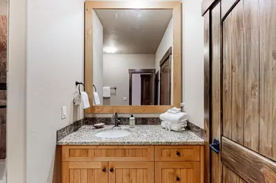 a bathroom with a sink and a large mirror at Frisco Frolic in Frisco