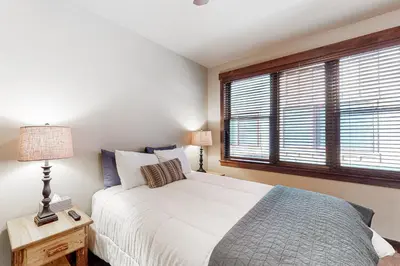 a bedroom with a white bed and a window at Frisco Frolic in Frisco