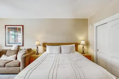 a bedroom with a large bed and a couch at Founders Pointe Condo in Winter Park