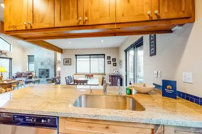 a kitchen with a sink and a living room at Dawn's Cabin in Frisco