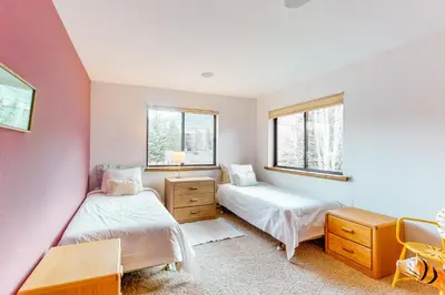 two beds in a room with two windows at Dawn's Cabin in Frisco