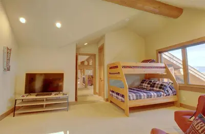 a bedroom with bunk beds and a flat screen tv at Good Elevations on Two Cabins Drive home in Silverthorne