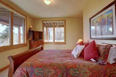 a bedroom with a bed with pillows and a tv at Good Elevations on Two Cabins Drive home in Silverthorne