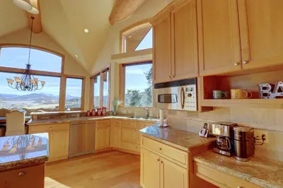 a large kitchen with wooden cabinets and windows at Good Elevations on Two Cabins Drive home in Silverthorne