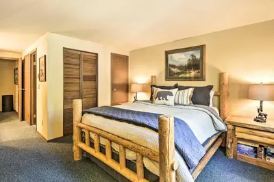 a bedroom with a large bed with a wooden frame at Cozy Ski Chalet Less Than 3 Mi to Winter Park Resort! in Winter Park
