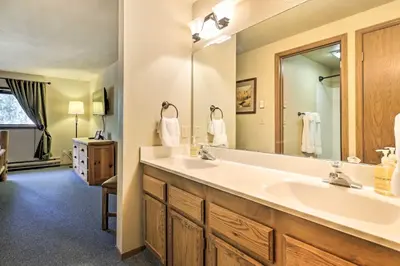 a bathroom with a sink and a large mirror at Cozy Ski Chalet Less Than 3 Mi to Winter Park Resort! in Winter Park