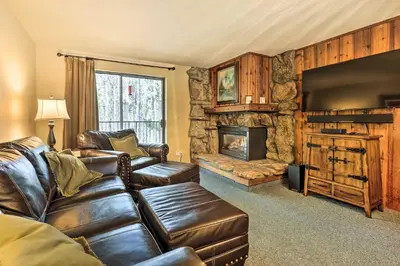a living room with a leather couch and a fireplace at Cozy Ski Chalet Less Than 3 Mi to Winter Park Resort! in Winter Park