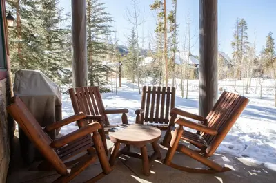 three rocking chairs and a table on a porch at 8750 Trappers Crossing condo in Keystone