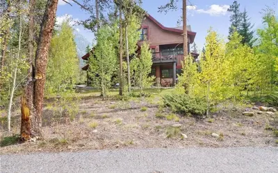 an image of a house with a yard with trees at 8750 Trappers Crossing condo in Keystone
