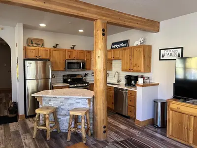 a kitchen with wooden cabinets and a kitchen island with stools at 8750 Trappers Crossing condo in Keystone