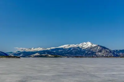 a snow covered mountain in front of a body of water at Marina Place 336 in Dillon