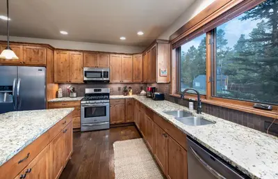 a kitchen with wooden cabinets and stainless steel appliances at Ridgeview Court Townhome: Incredible Rooftop Deck in Frisco